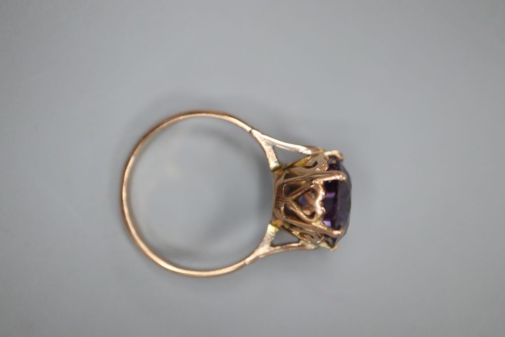 A yellow metal and synthetic colour change corundum set oval dress ring, size O, gross 3.9 grams.